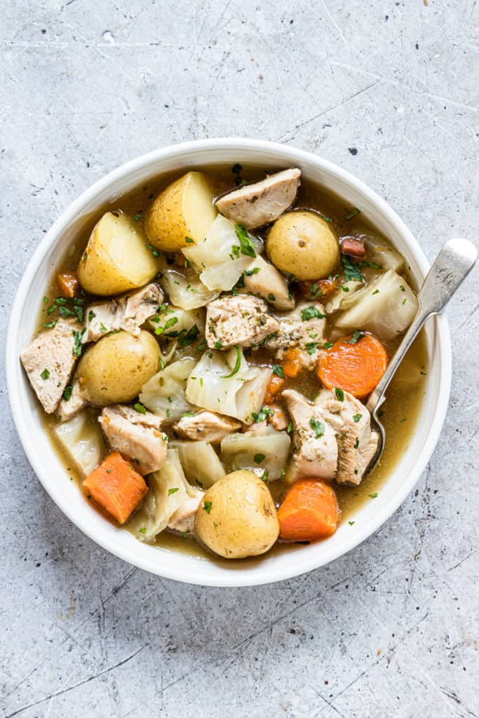 a bowl of the finished pressure cooker chicken stew served with a silver spoon