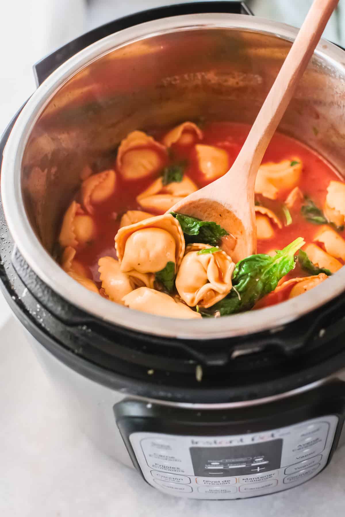 top down view of the finished instant pot chicken tortellini soup inside the instant pot