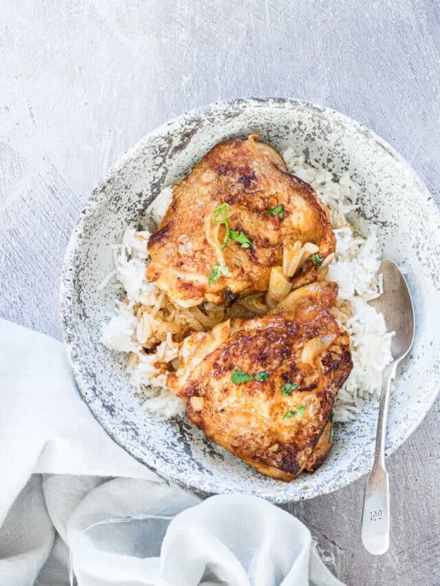 two pieces of cinnamon chicken served with rice in a blue ceramic bowl