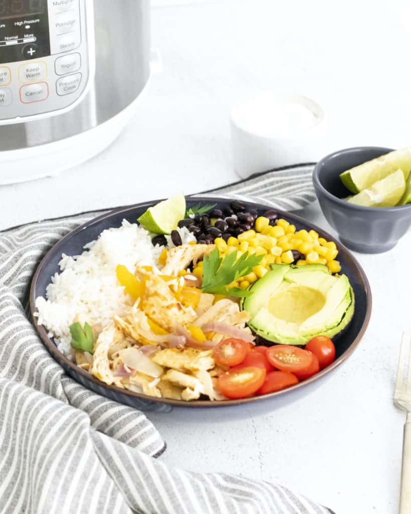 the chicken burrito bowl served in a black bowl placed in front of the instant pot