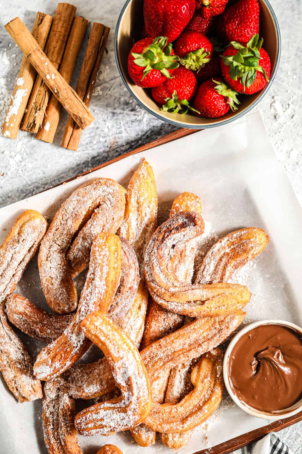 a tabletop of churros with strawberries