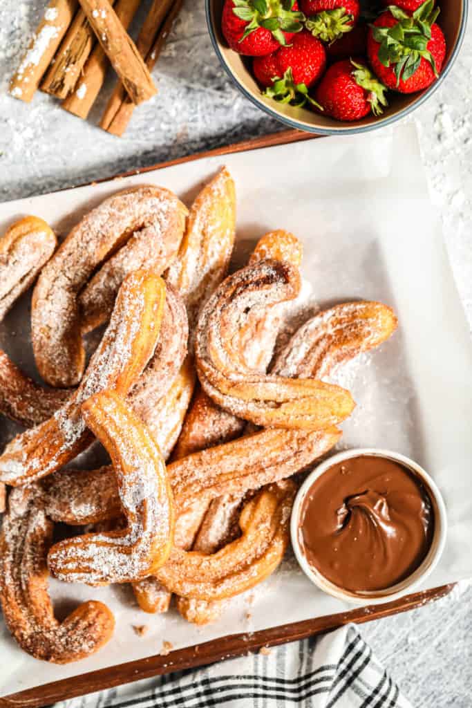 close up of a churros platter on a table with strawberries