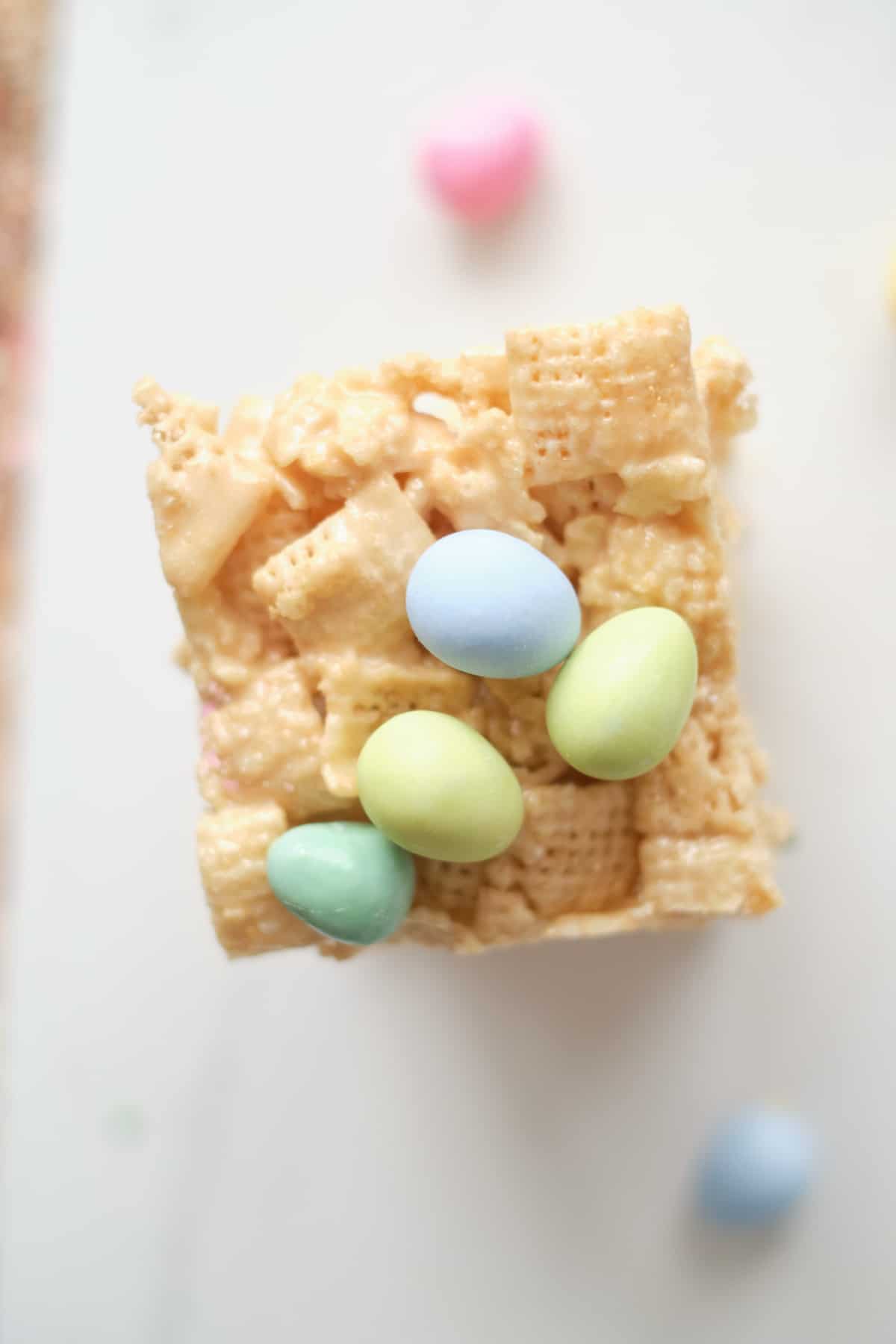 one of the completed no bake chex bars on a countertop next to mini eggs