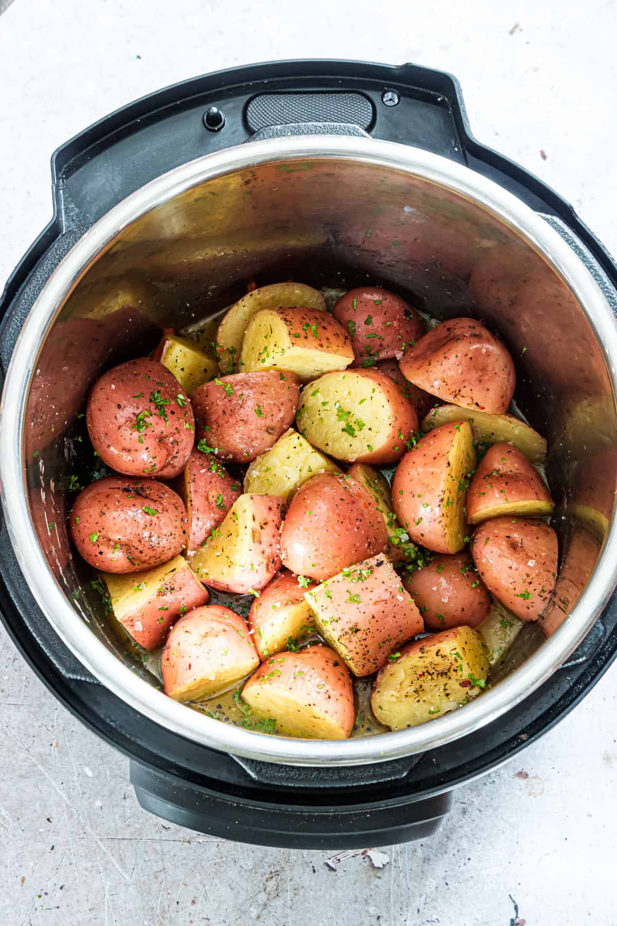 Top and bottom view of finished instant pot red potatoes inside a pressure cooker
