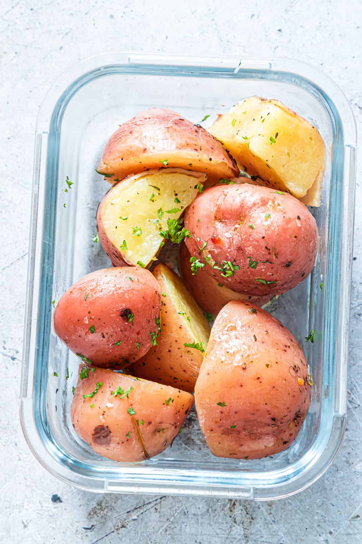 a serving of instant pot red potatoes in a glass food storage container