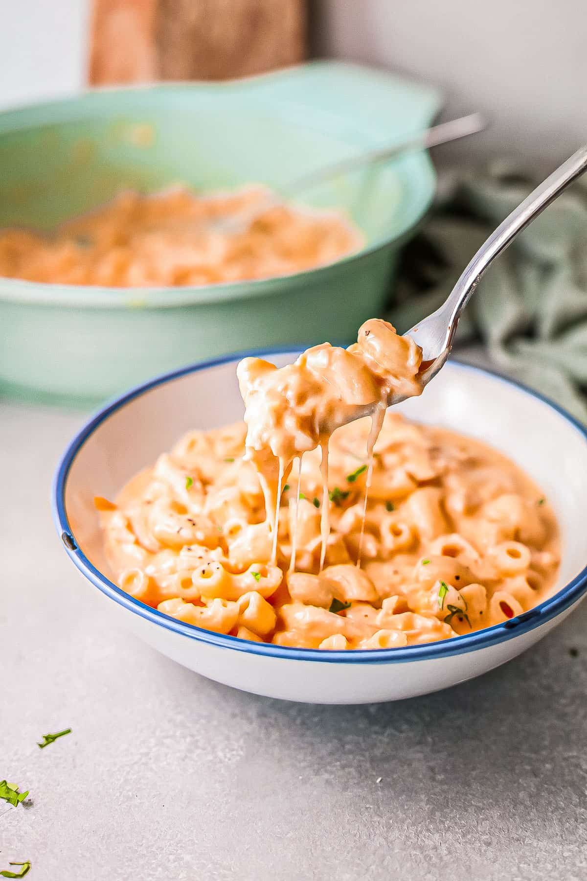 a bowl of buffalo chicken mac and cheese with a fork removing a bite