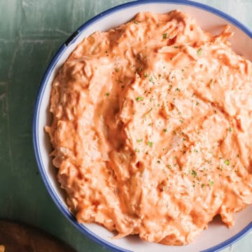 close up view of the finished crockpot buffalo chicken dip served in a ceramic bowl