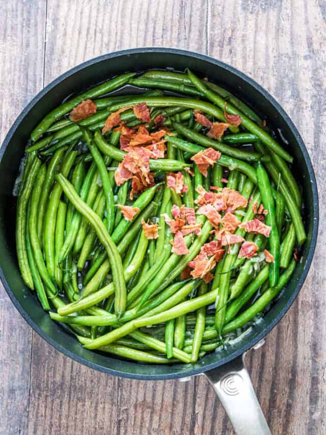 top down view of the cooked green beans with bacon inside a skillet