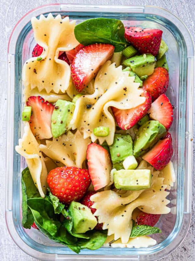 one serving of strawberry avocado pasta salad inside a glass food storage container