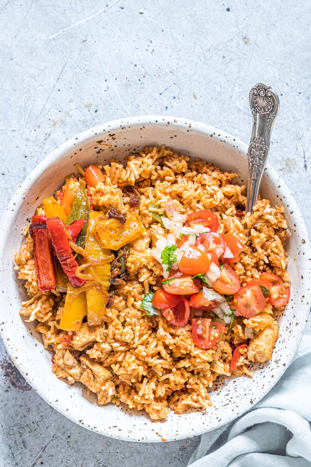 top down view of a serving of instant pot fajita rice with a spoon and cloth napkin