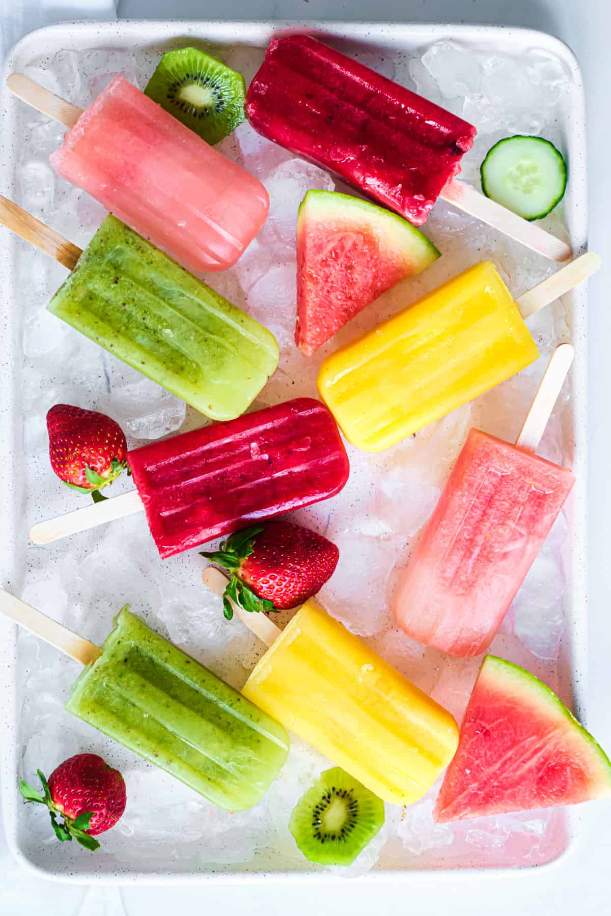 a tray with different mexican popsicles (ice lollies) with fruit and ice on a tray