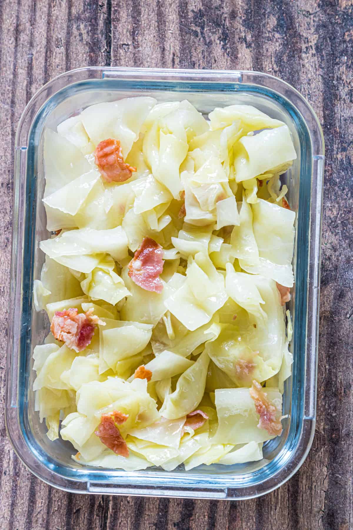 the finished smothered cabbage inside a glass food storage container