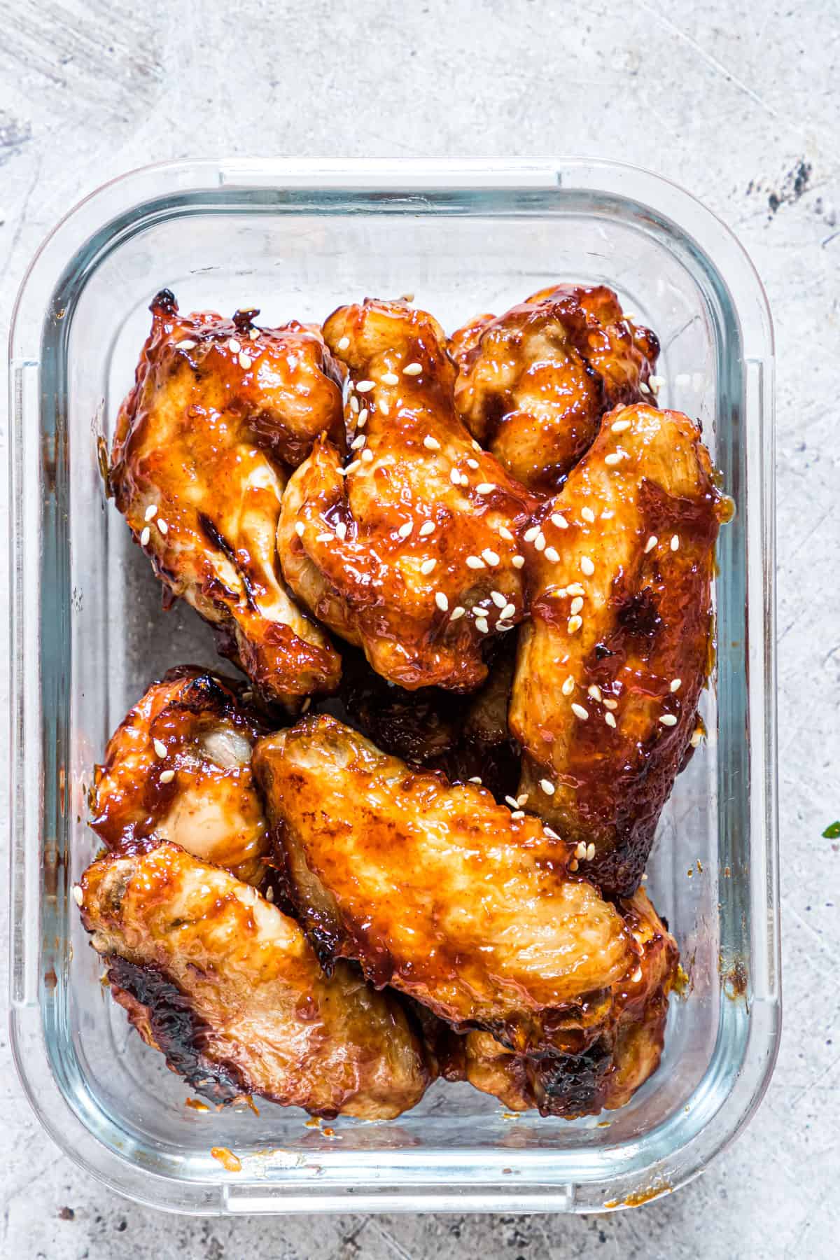 sticky air fryer chicken wings inside a glass meal prep container