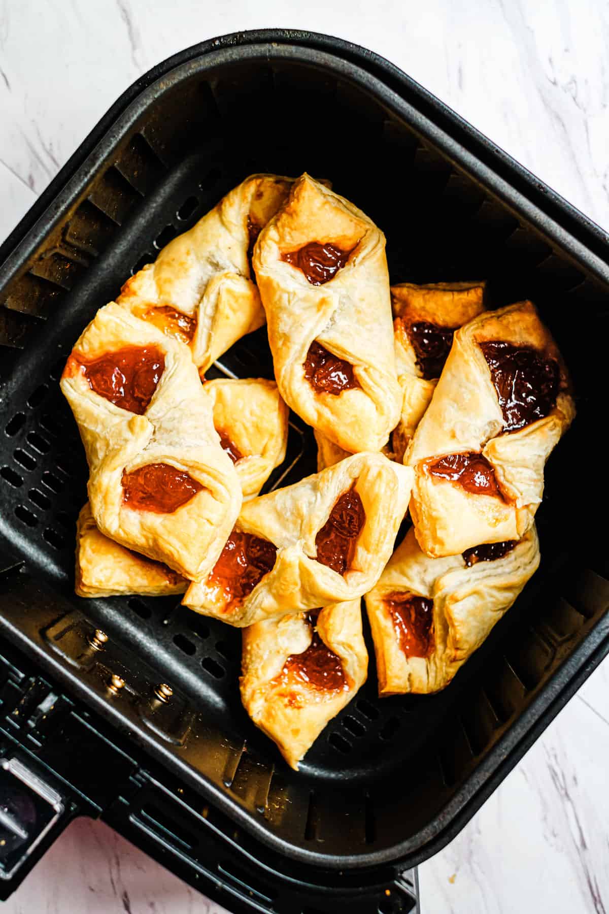 top down view of the cooked puff pastry breakfast bites inside the air fryer basket
