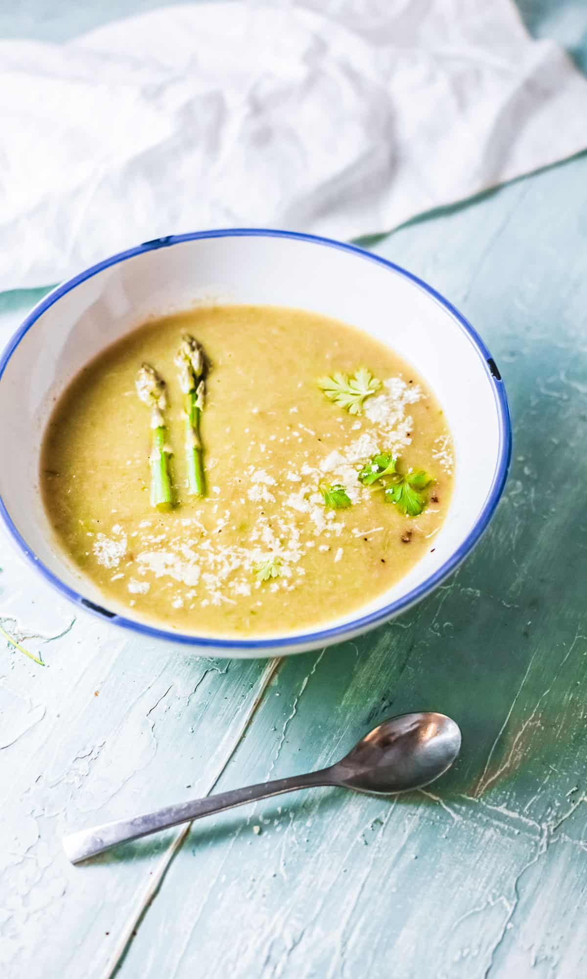 the completed asparagus soup instant pot recipe served in a ceramic bowl with a spoon