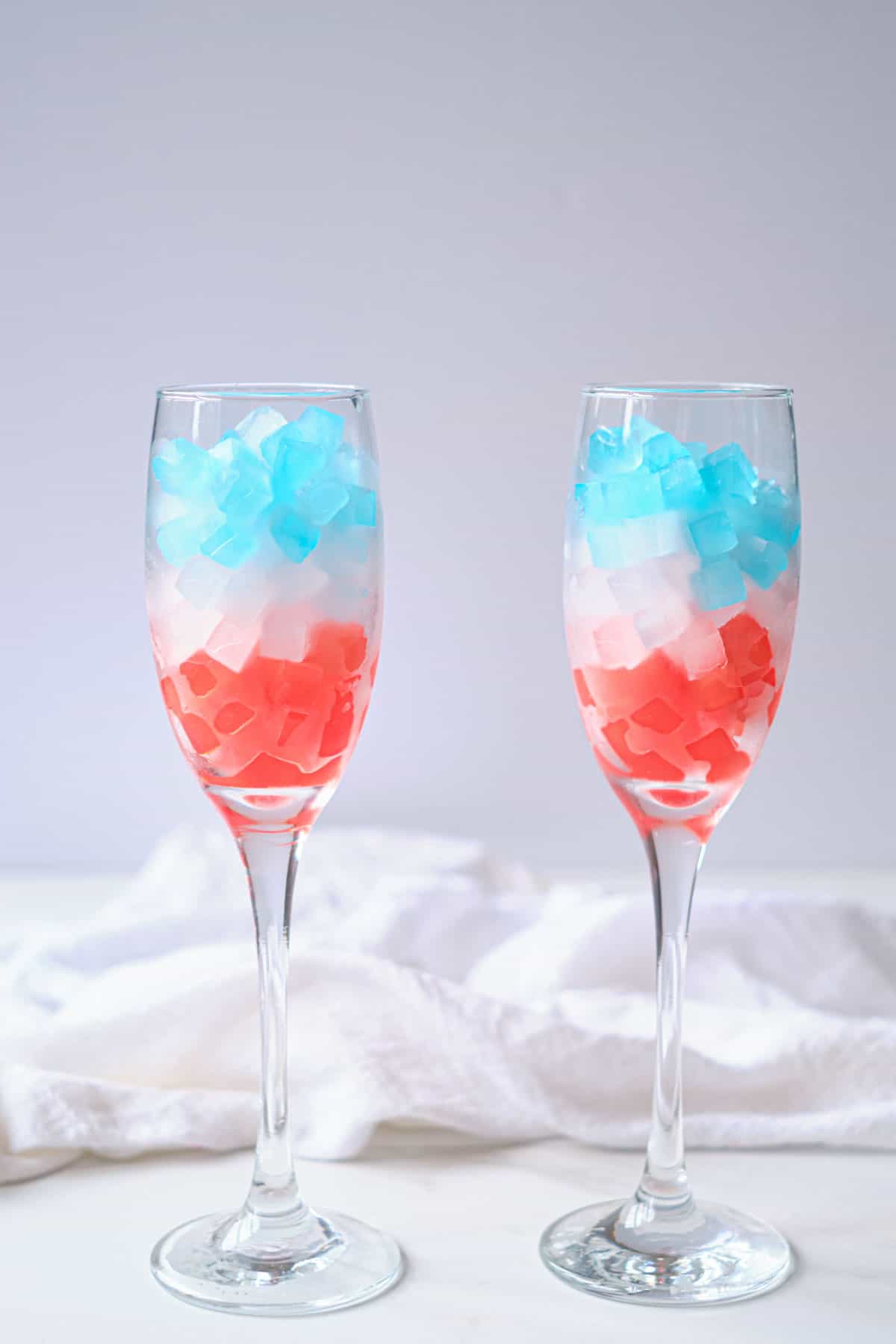 2 glasses filled with layers of patriotic ice cubes