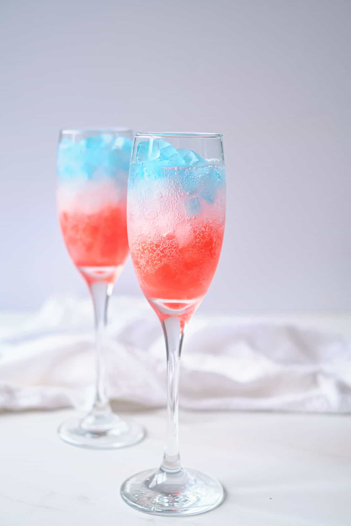Red, white and blue ice cubes in a glass with some sprite