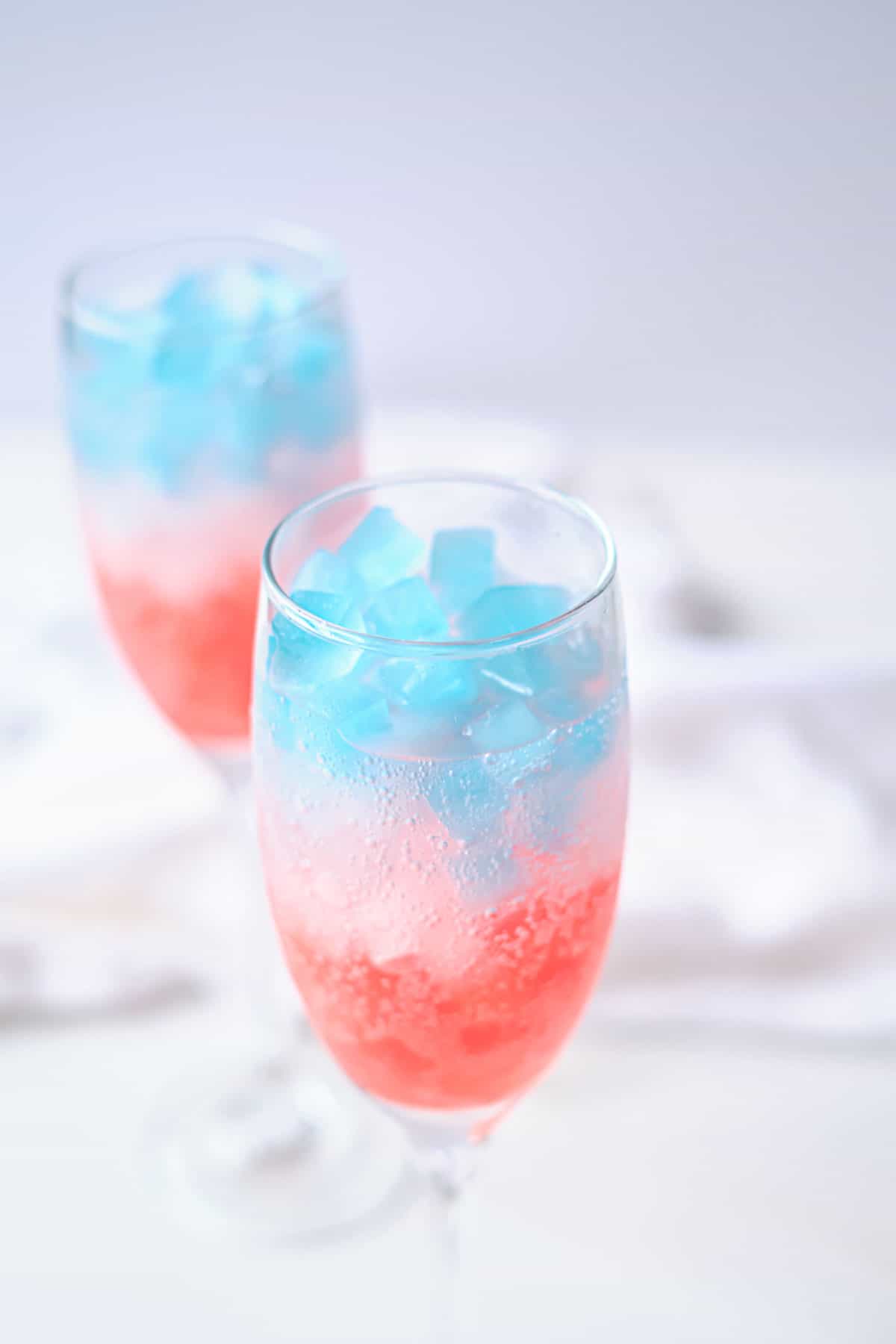 2 glasses filled with patriotic ice cubes in some sprite