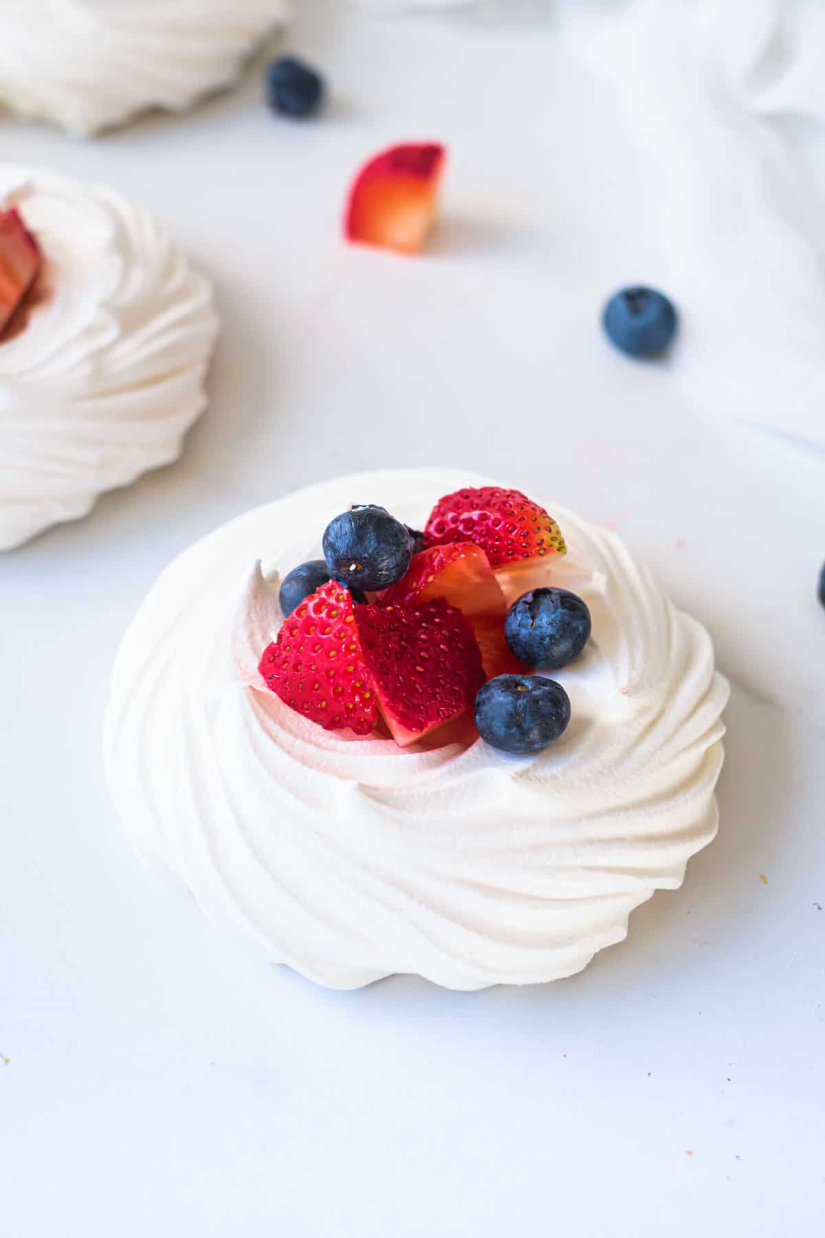 close up of a berry filled mini pavlova nest