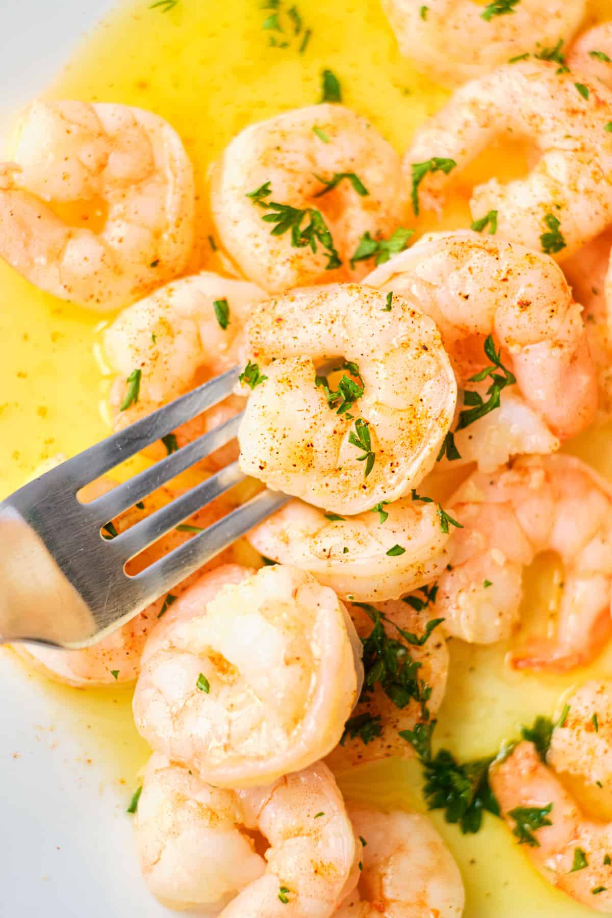 Air Fryer shrimp with Garlic butter on a plate with a fork taking some