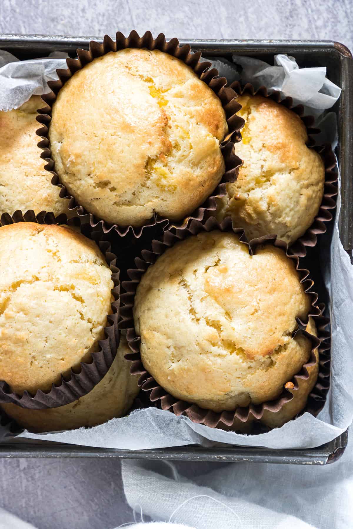 a container filled with baked pineapple muffins