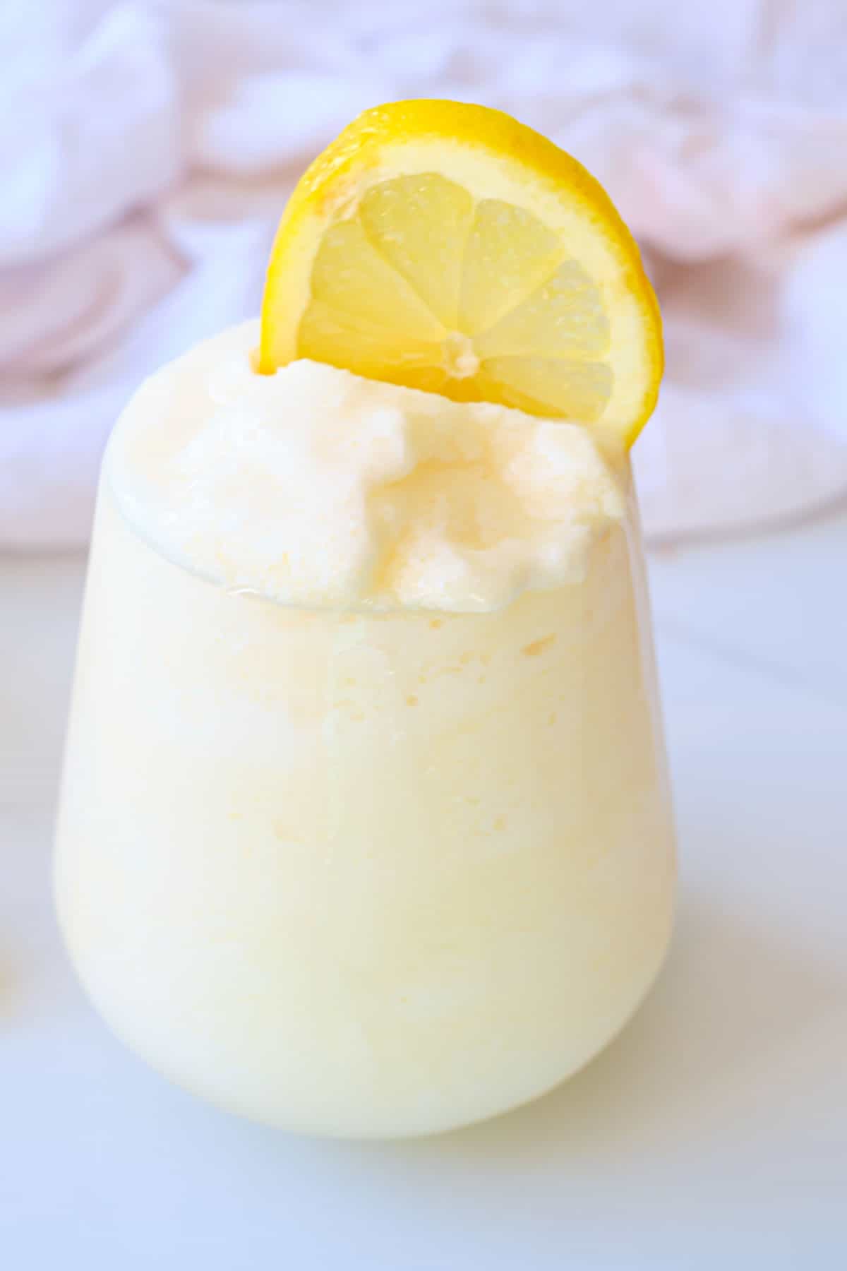 close up of frosted lemonade with lemon slsices garnish