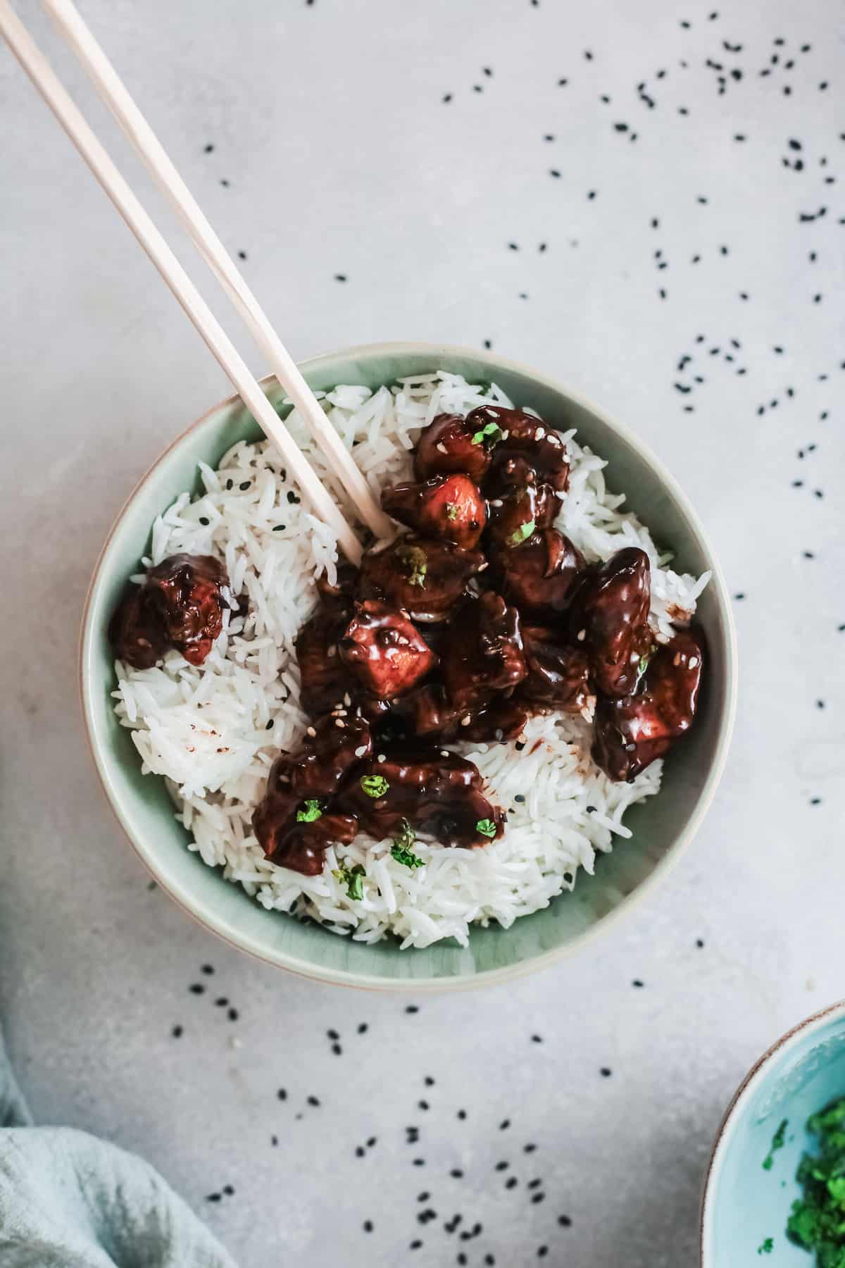 a green bowl filled with rice and air fryer general tsos chicken