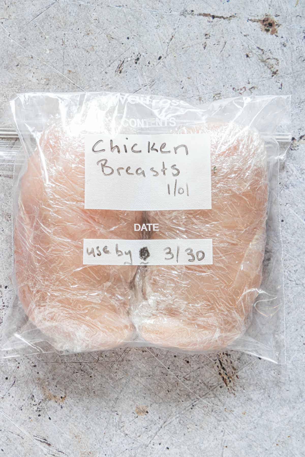 two chicken breasts in a plastic freezer bag