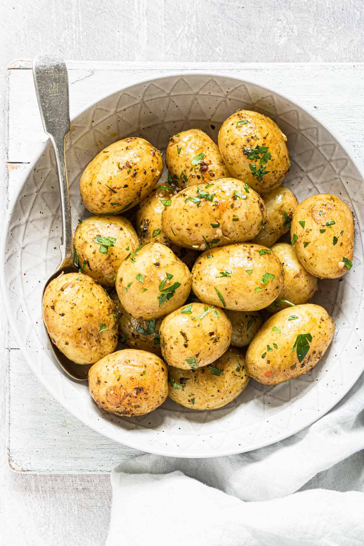 A plate full of cooked instant pot baby potatoes with herbs