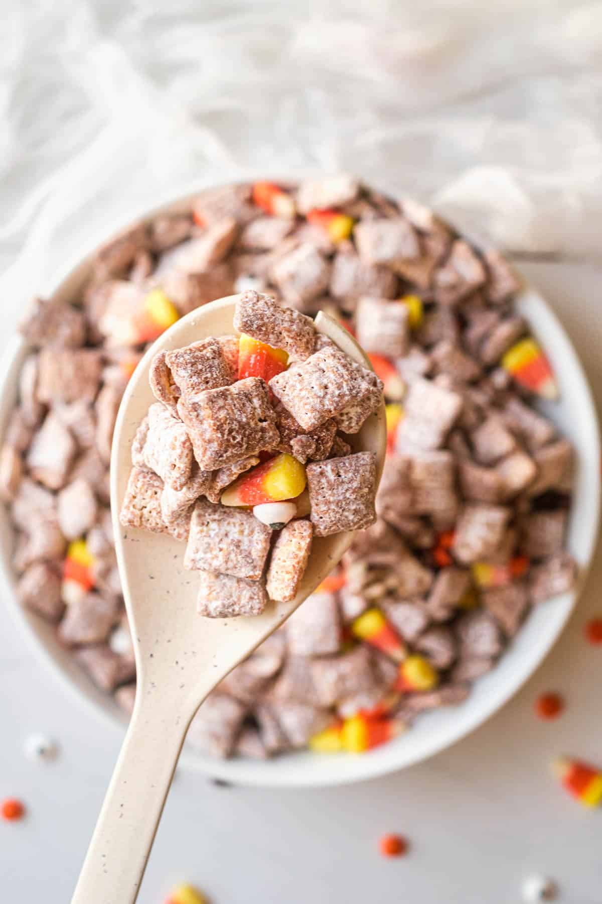 Close up of halloween muddy buddies in a bowl with some scooped out