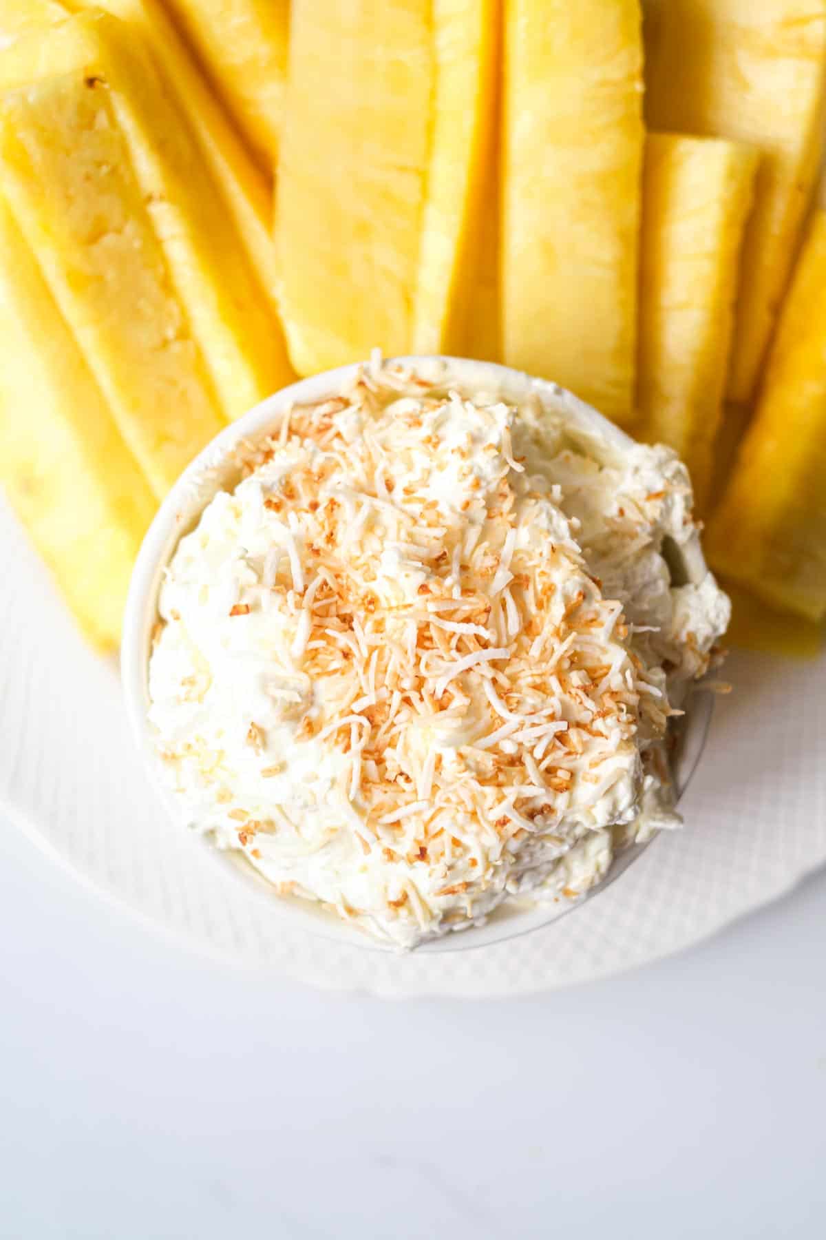 the finished pina colada cream cheese dip with pineapple spears