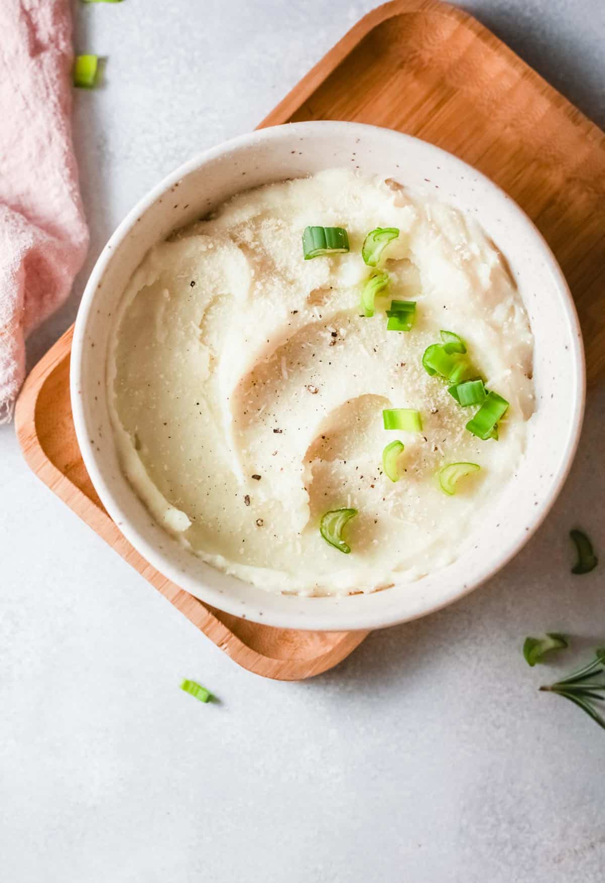 a white bowl filled with roasted garlic mashed potatoes