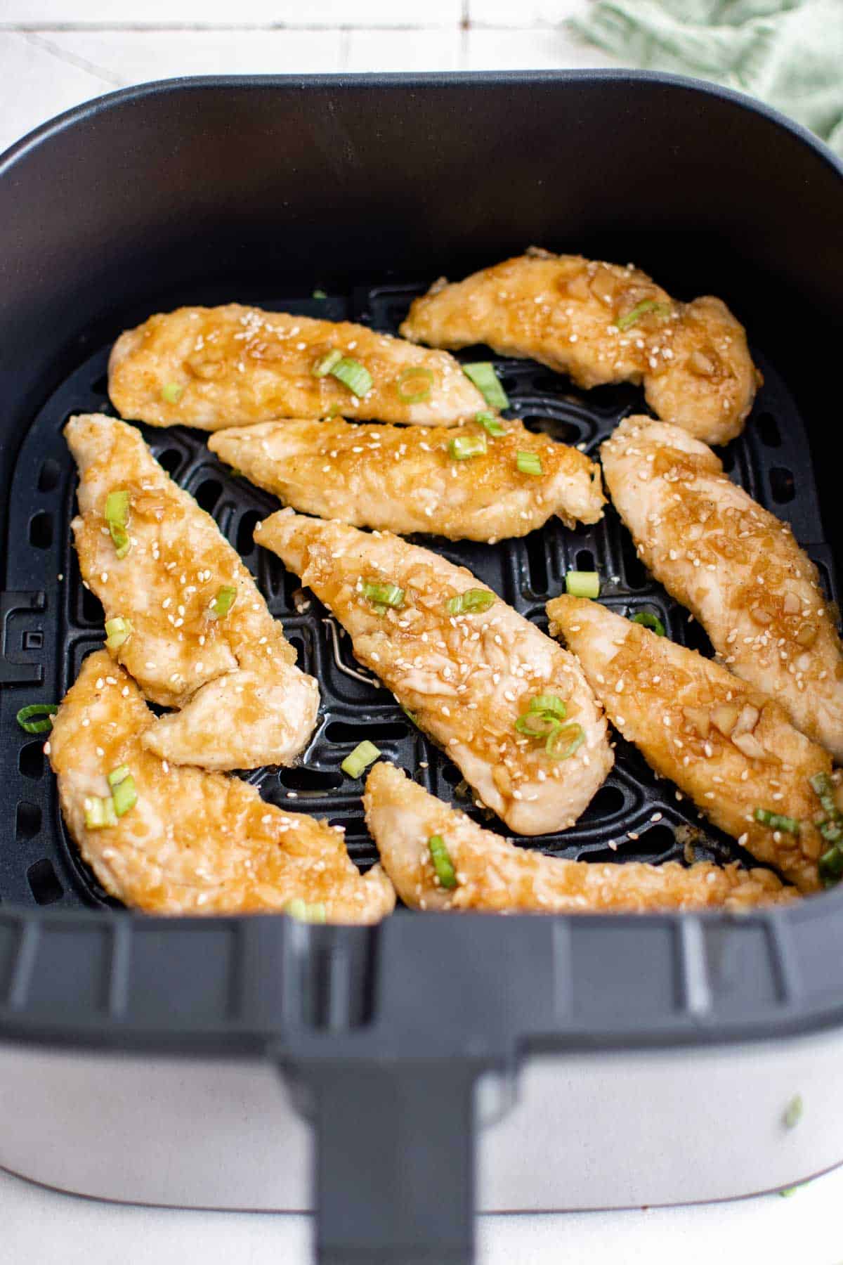 cooked chickebn tenders inside the air fryer basket