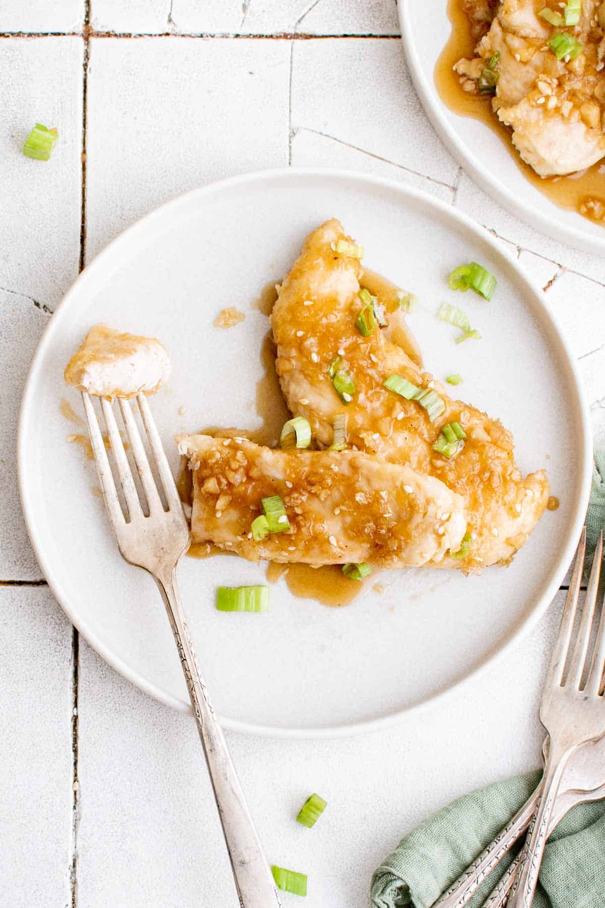 top down view of the finished honey garlic chicken tenders on a white plate