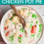 a bowl of chicken pot pie with a wooden spoon