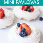 three mini pavlovas topped with strawberries and blueberries