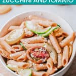 a bowl of pasta with zucchini and tomato