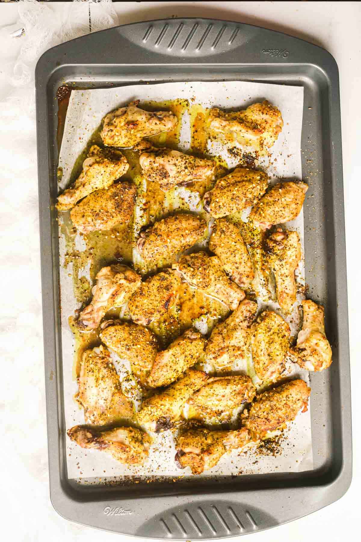 top down view of a baking tray filled with lemon pepper chicken wings