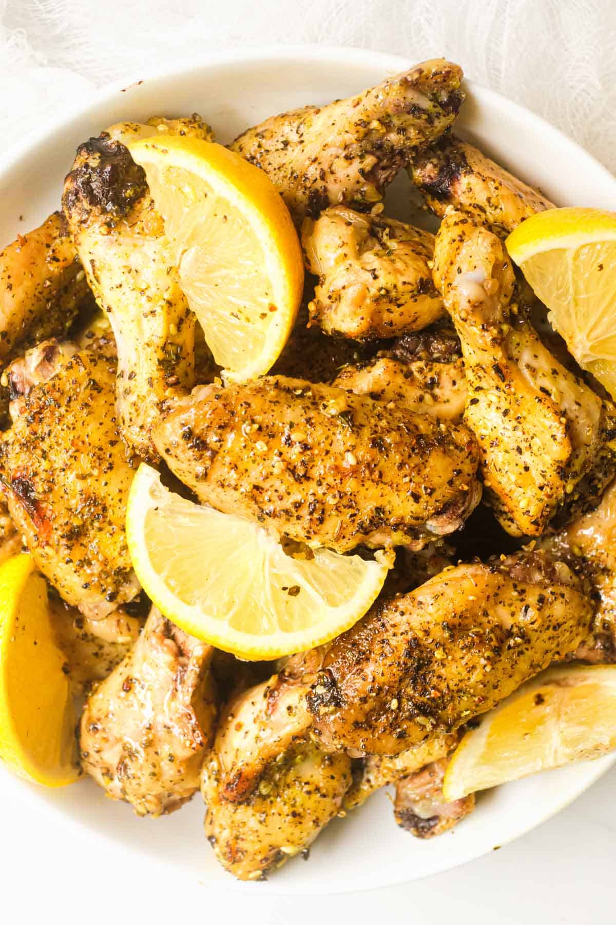 a white bowl filled with the completed lemon pepper chicken wings
