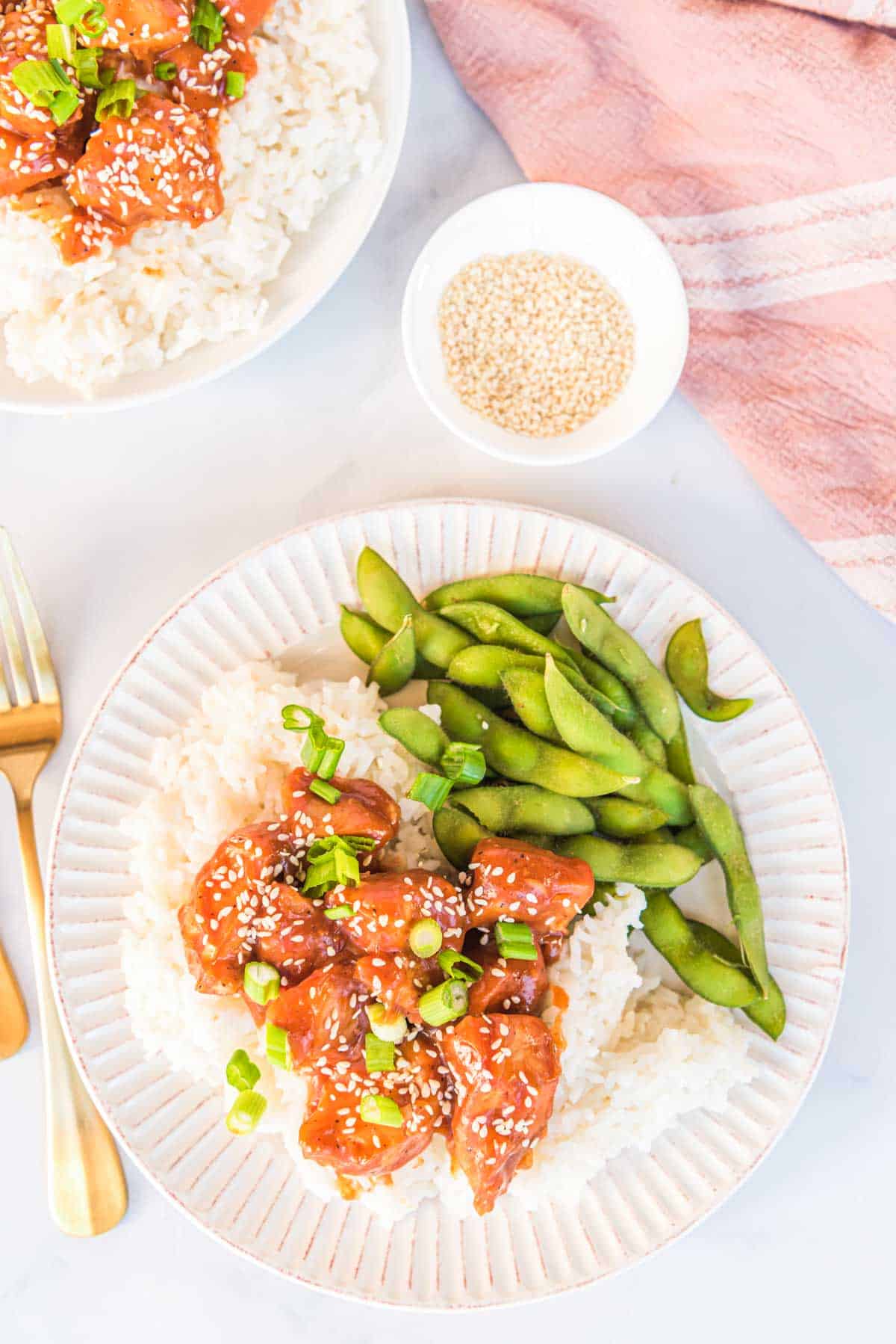a white dinner plate filled with rice, vegetables and slow cooker honey garlic chicken
