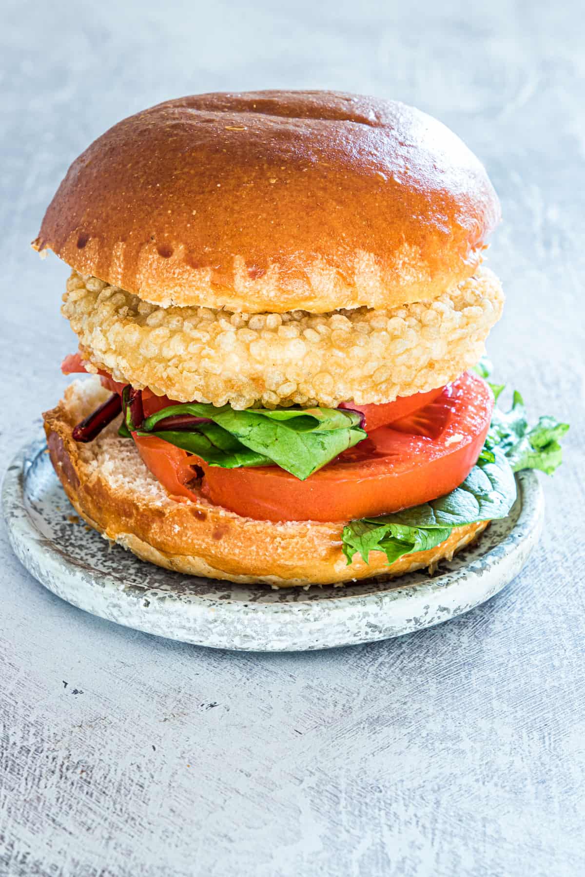 one of the cooked frozen chicken patties in air fryer served on a bun with lettuce and tomato