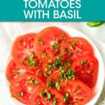 sliced tomatoes on a plate sprinkled with chopped basil