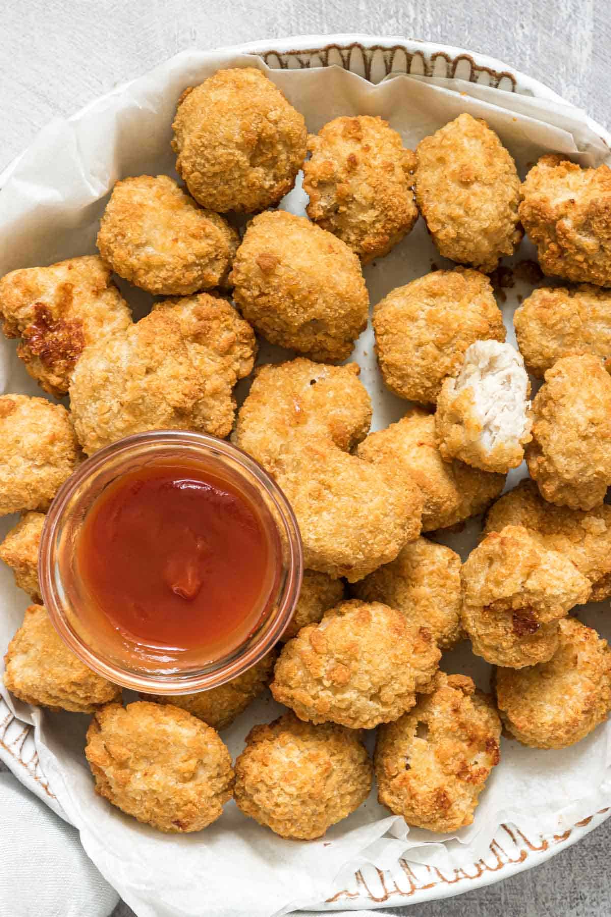 close up view of the finished air fryer frozen chicken nuggets served with dipping sauce