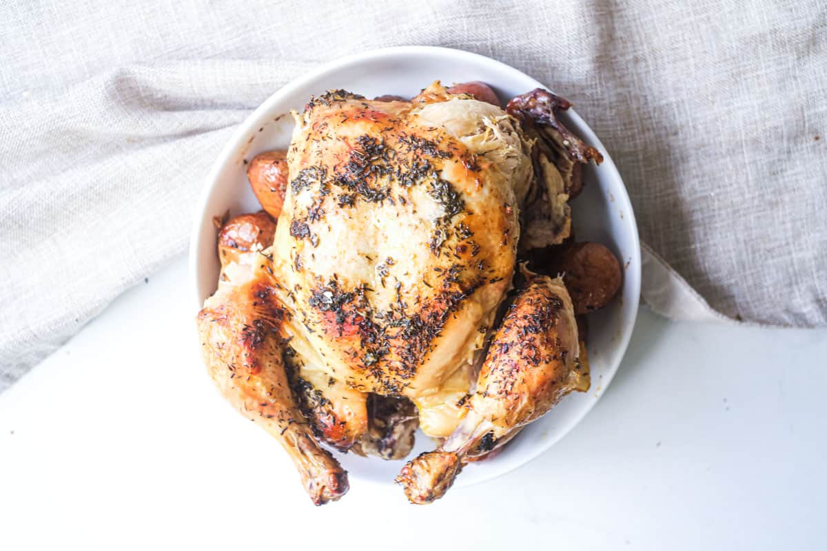 the cooked dutch oven roast chicken on a white plate