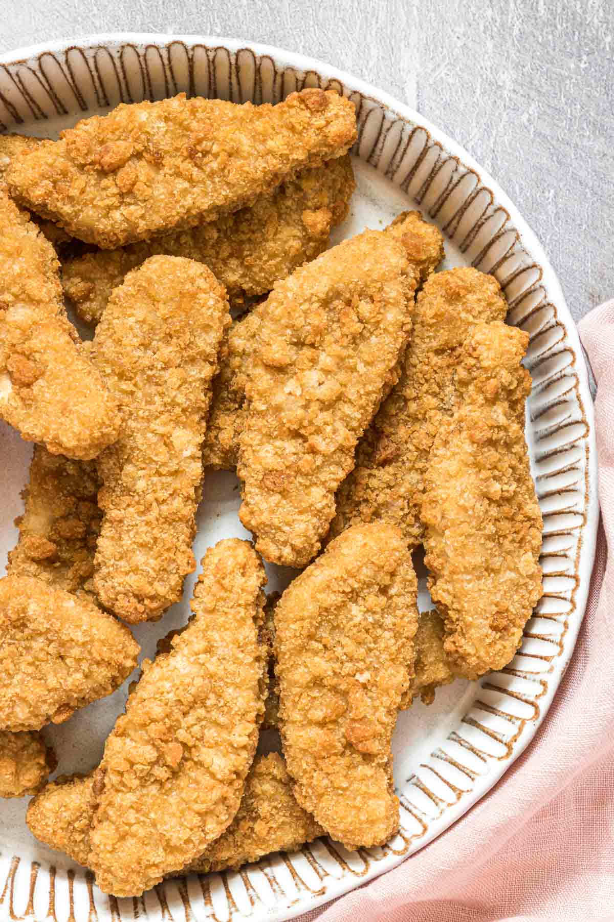 a plate of cooked frozen breaded chicken tenders