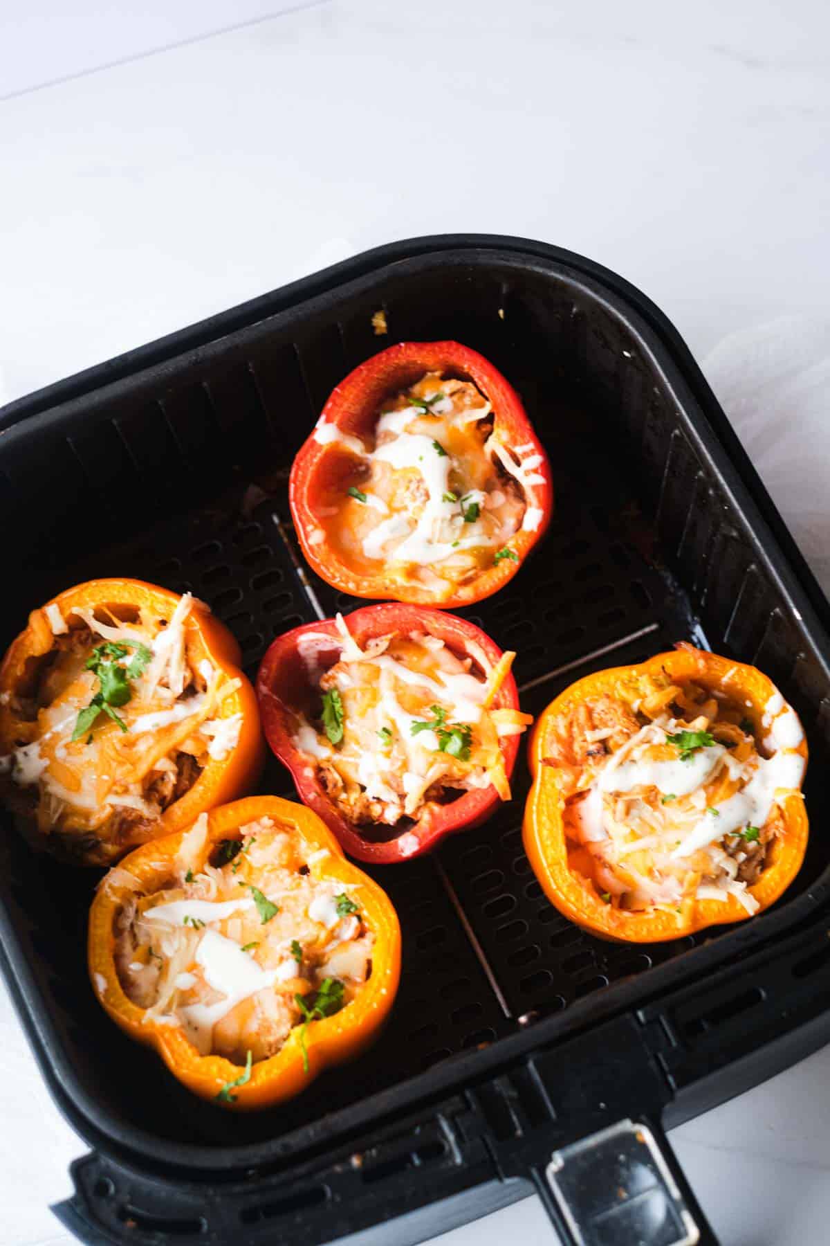 top down view of the air fryer stuffed peppers inside the air fryer basket