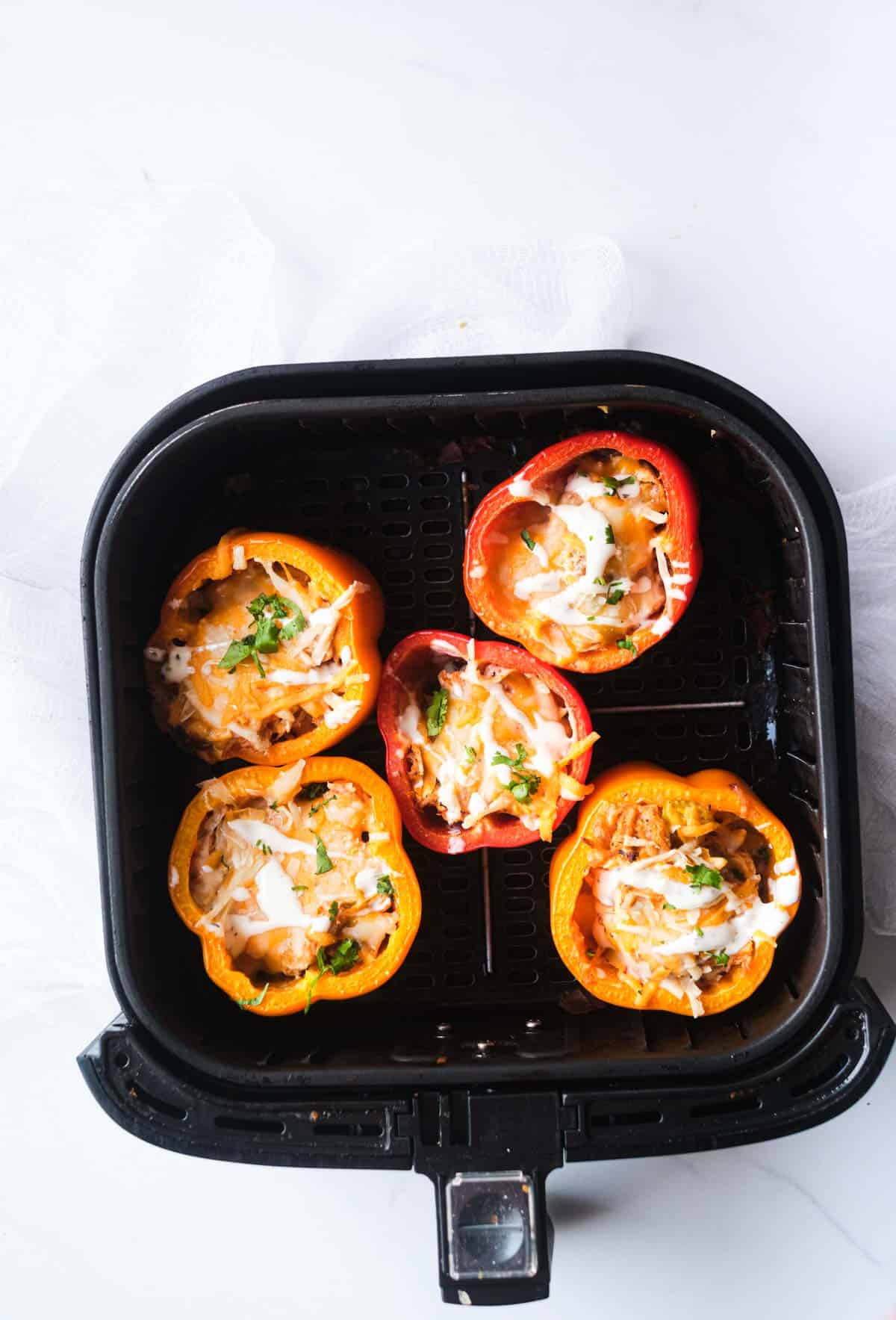 top down view of the cooked buffalo chicken air fryer stuffed peppers inside the air fryer basket