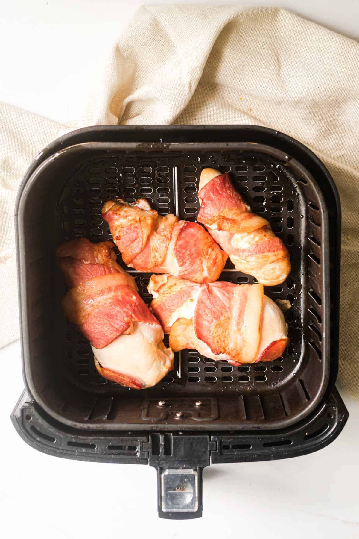 top down view of the cooked bacon wrapped chicken in air fryer basket