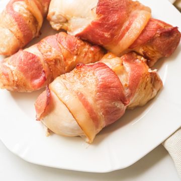 the finished bacon wrapped chicken breast on a white plate