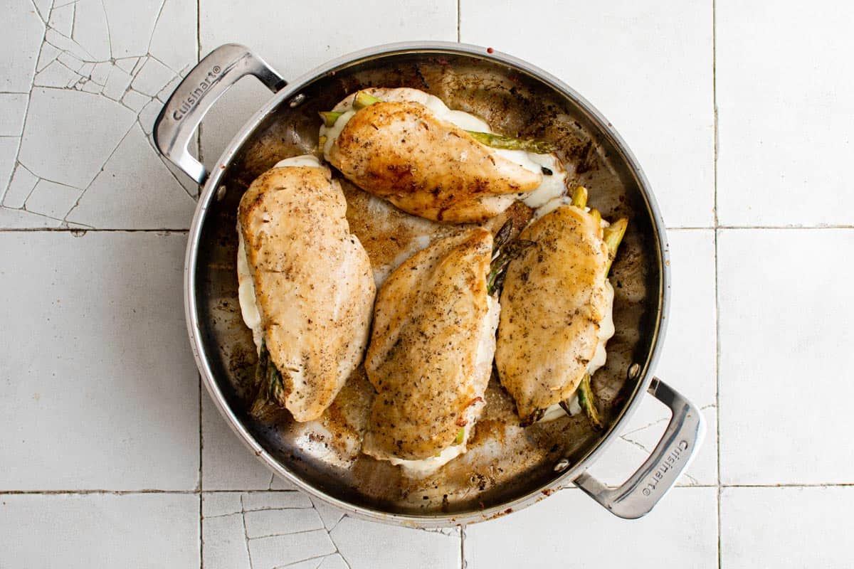 the cooked asparagus stuffed chicken breast inside the skillet